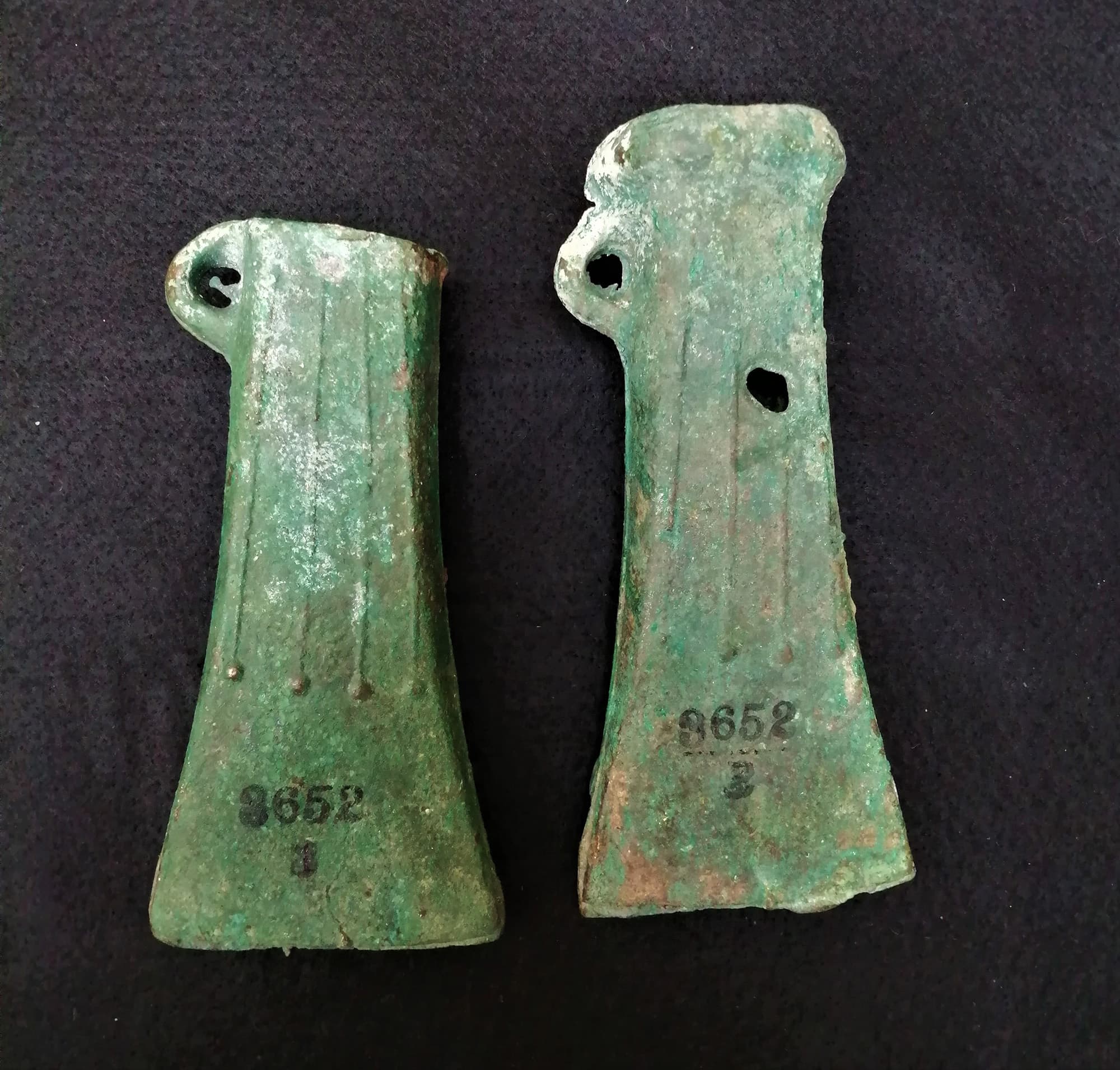 Two axes from the same mould showing casting mistakes